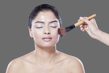 Young model with makeup brushes