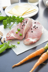 Raw pork and vegetables on black table