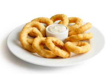 Heap of deep fried onion or calamari rings with chilli dip on wh