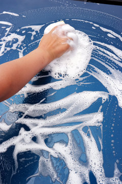 The hand of a child washing a car