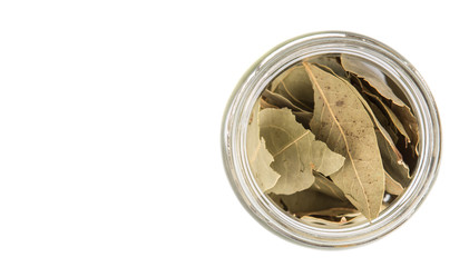 Dried bay leaves herbs in a mason jar over white background