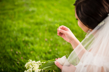 Bride on her wedding day with lucky fortune clover 