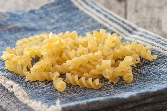 Raw pasta isolated on blue (spiral shaped)