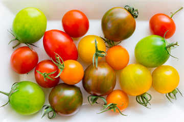 Colorful cherry tomatoes on white background.