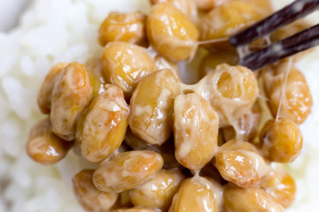 Chopsticks and fermented soybeans on the white rice.