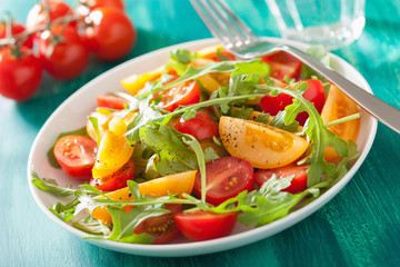 tomato salad with arugula over green background