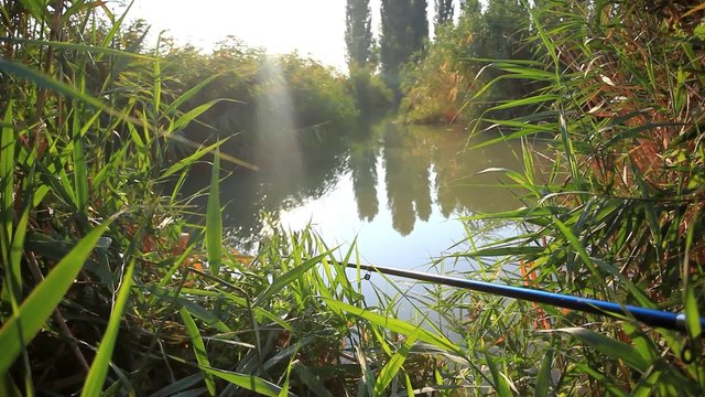 Fishing  in sunrise. Sunlight shines in the water. Spinning on
