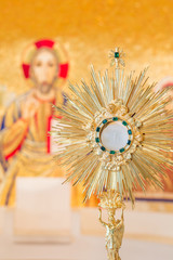 Eucharistic adoration monstrance on the altar with the image of Jesus Christ in the background