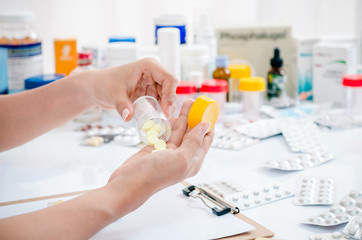 pharmacist handling medicine in a clear container 
