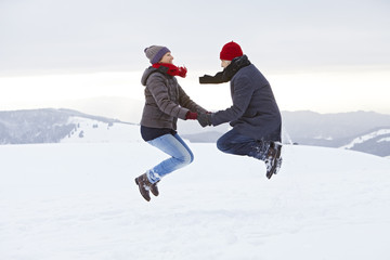 Fototapeta na wymiar Paar Mann Frau Berg Winter Schnee springen