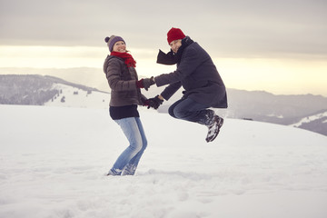 Fototapeta na wymiar Paar Mann Frau Berg Winter Schnee springen