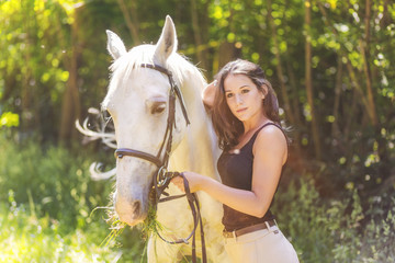 Outdoor photo from a beautiful young women with her horse