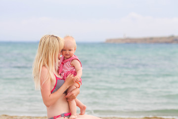 Naklejka premium Mother holds the child on hands at the sea