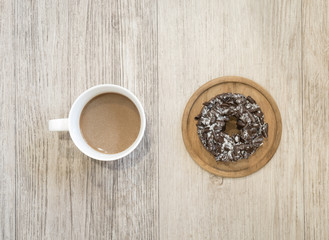 Chocolate Donut and cup of coffee on wooden background