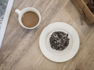 Chocolate Donut and cup of coffee on wooden background