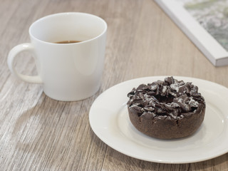 Chocolate Donut and cup of coffee on wooden background