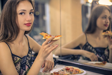 Young woman eating a tasty pizza