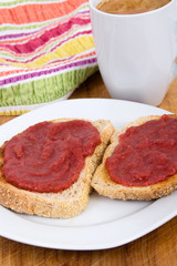 Strawberry and rhubarb jam on toast bread for breakfast on table