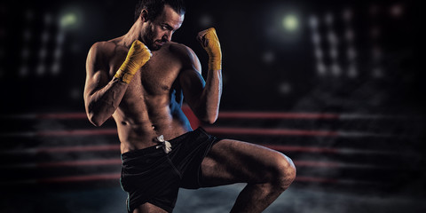 Strong muscular boxer in red boxing gloves. A man in a boxing