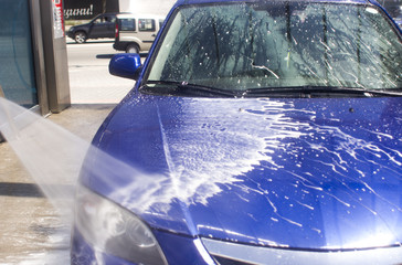 Car wash with flowing water and foam.
