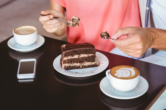 Cute Couple On A Date Sharing A Piece Of Chocolate Cake