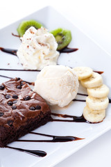 Brownie and ice cream with whipping cream and banana slices