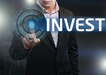 Businessman presses button invest on virtual screens. Business,