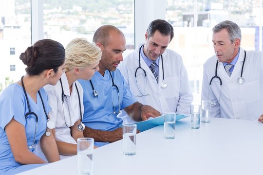 Doctor showing clipboard to his colleagues 
