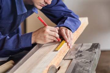 Fototapeta na wymiar Carpenter marking a piece of wood