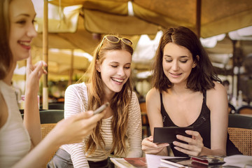 Three girls sitting at a cafe