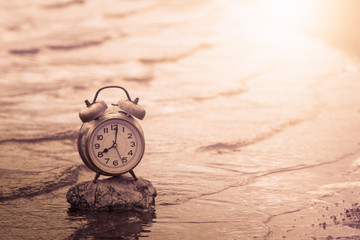 retro clock on rock in wave of water in lake,vintage filter
