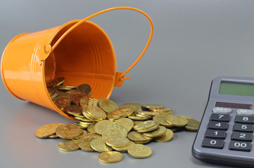 Gold Coins, Calculator and Bucket - Business Concept