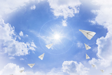paper airplane flying towards sun