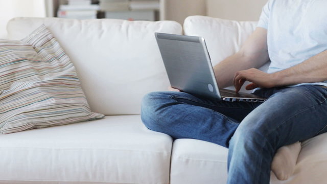 close up of man typing on laptop at home