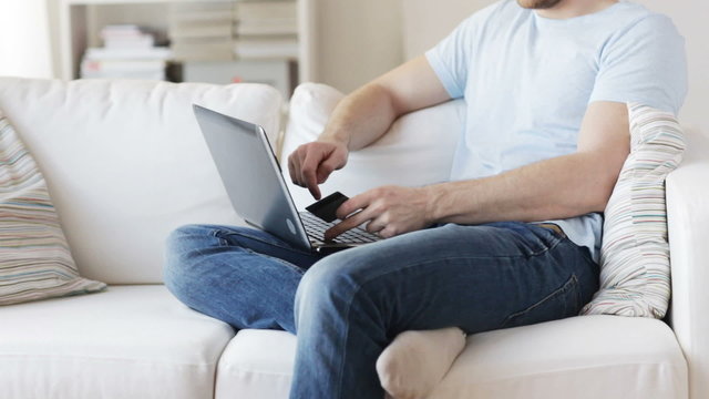 close up of man with laptop and credit card