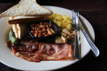 Breakfast with ham , fried egg and bread on wood background low