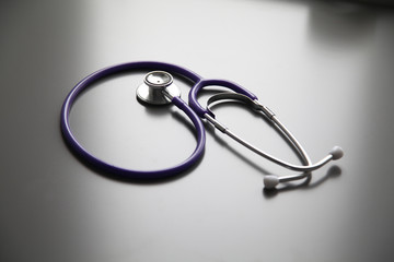 Fototapeta premium Stethoscope on the grey desk, close up