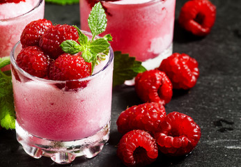 Raspberry granita with berries and mint in glass cups, selective