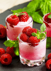 Raspberry granita with berries and mint in glass cups, selective