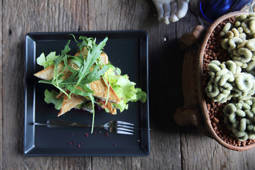 Sandwiches with meet and vegetables on wood background