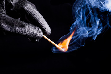 Close-up of hand with match flame - obrazy, fototapety, plakaty