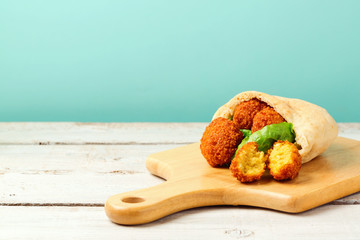 Falafel balls served with pita and lettuce on a wooden board