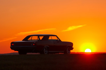 Naklejka na ściany i meble Retro car silhouette on sunset