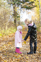 Fototapeta na wymiar little girls wearing rubber boots in autumnal nature