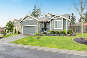 Beautiful modern home with grass and driveway.