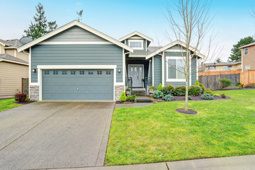 Beautiful modern home with grass and driveway.