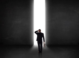 Business person looking at wall with light tunnel opening