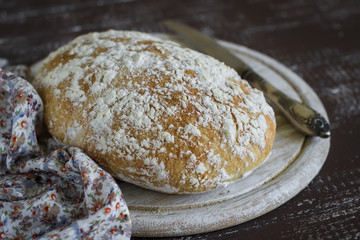 homemade rustic bread on a dark wooden surface