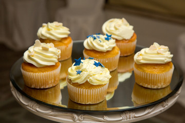 Dolcetti con crema, stelline e cuoricini su vassoio specchiato