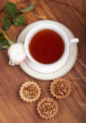 Cup of tea with cake on wood table, view from above